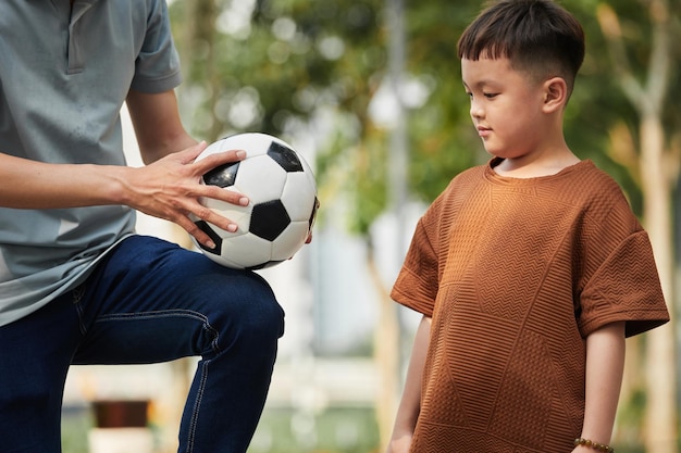 Junge lernt Fußball spielen