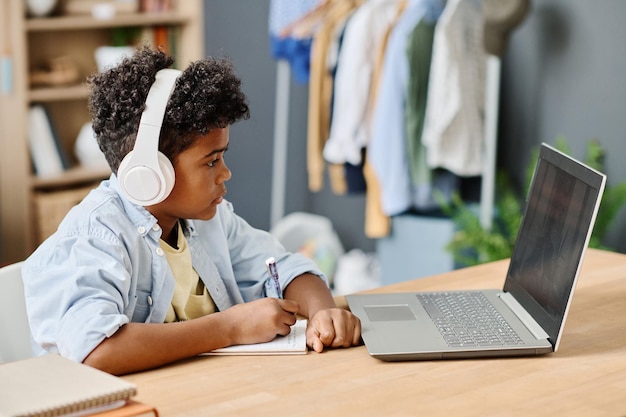 Junge lernt zu Hause mit Laptop