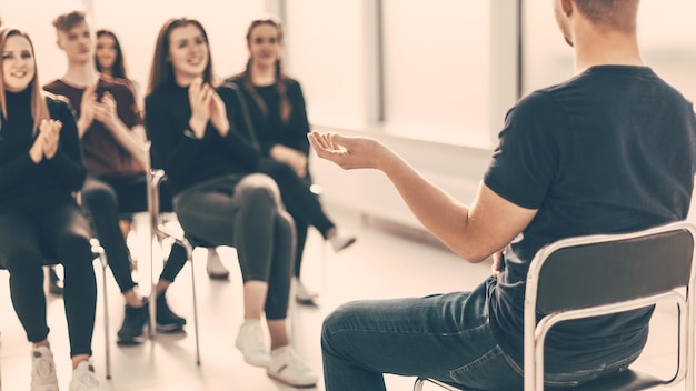 junge Leute applaudieren dem Wirtschaftssprecher