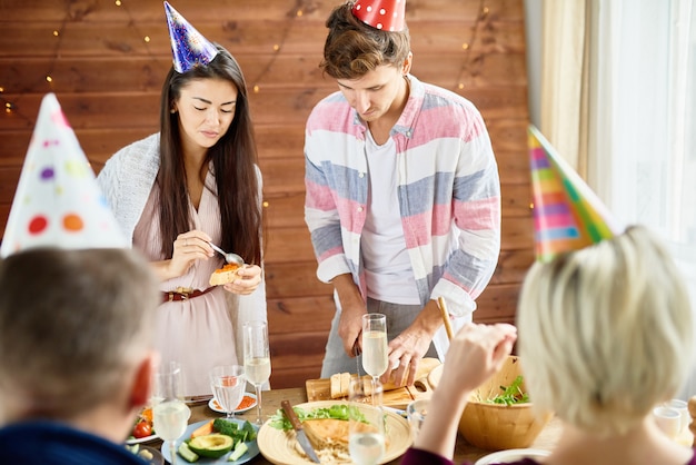 Junge Leute, die an der Geburtstagsfeier essen