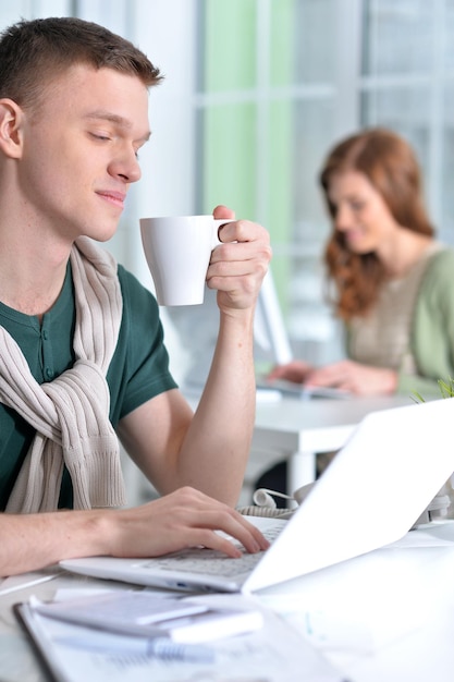 Junge Leute, die im Büro mit modernen Geräten arbeiten