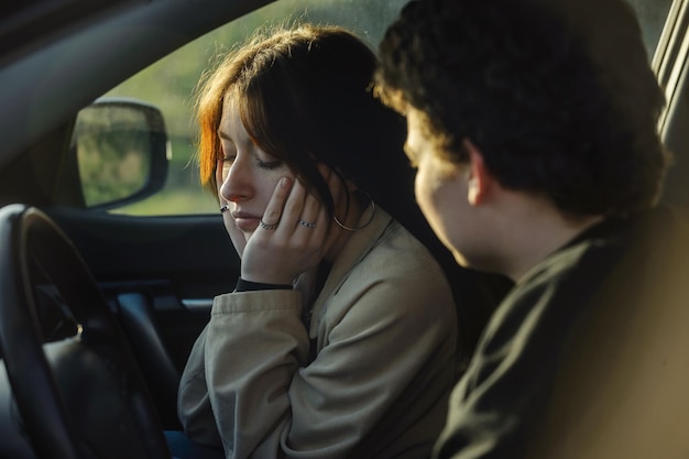 junge leute ein verliebtes paar kerl und mädchen streiten sich, während sie in einem auto unterwegs sind