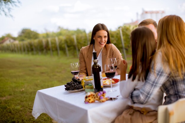 Junge Leute genießen das Abendessen und die Weinprobe im Weinberg