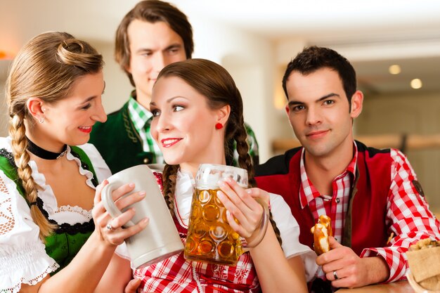 Junge Leute im traditionellen bayerischen Tracht im Restaurant oder in der Kneipe