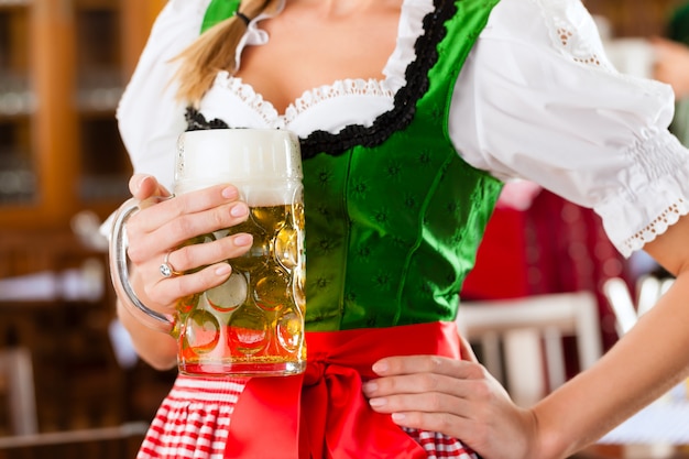 Junge Leute im traditionellen bayerischen Tracht im Restaurant oder in der Kneipe