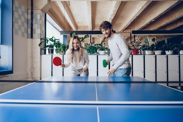 Junge Leute, Mann und Frau, die Tischtennis spielen