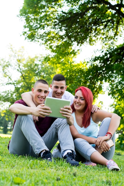 Junge Leute mit Tablette im Park