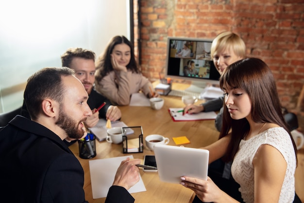 Junge leute reden, arbeiten während einer videokonferenz mit kollegen im büro oder wohnzimmer