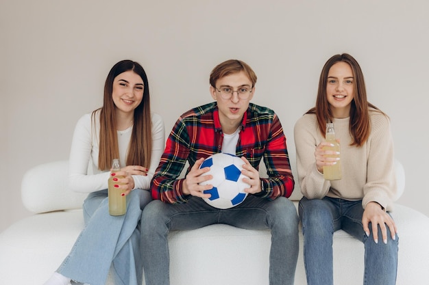 Junge Leute sehen sich ein Fußballspiel mit unterschiedlichen Emotionen im Gesicht an Fußballfans Freunde zu Hause