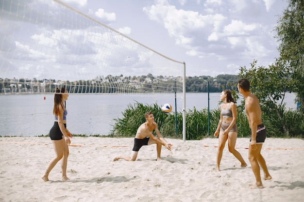 Junge Leute spielen Volleyball am Strand