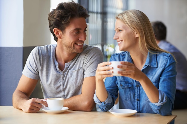 Junge Liebe Schnappschuss eines liebevollen jungen Paares in einem Café