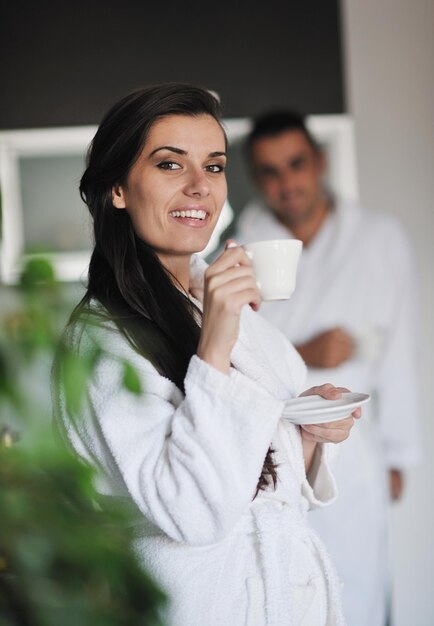 Junge Liebespaare, die in der modernen Wohnung einen frischen Morgenkaffee trinken