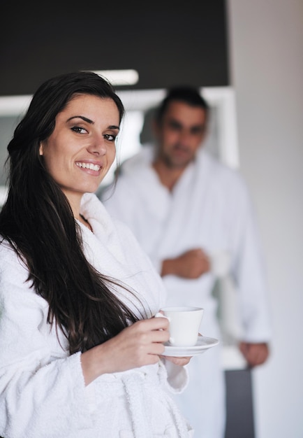 Junge Liebespaare, die in der modernen Wohnung einen frischen Morgenkaffee trinken