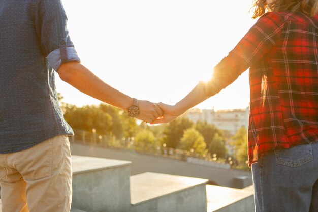 Junge Liebespaare halten sich bei Sonnenaufgang an den Händen. Zeit zusammen verbringen. Liebeskonzept