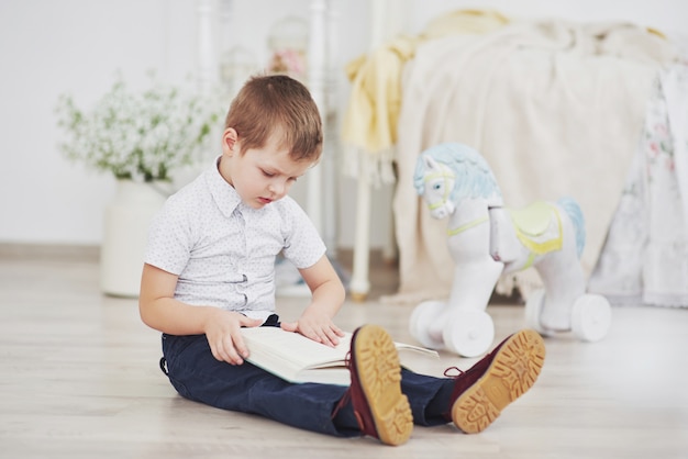 Junge liest ein Buch. Bildung, Wissen, sich auf die Schule vorbereiten