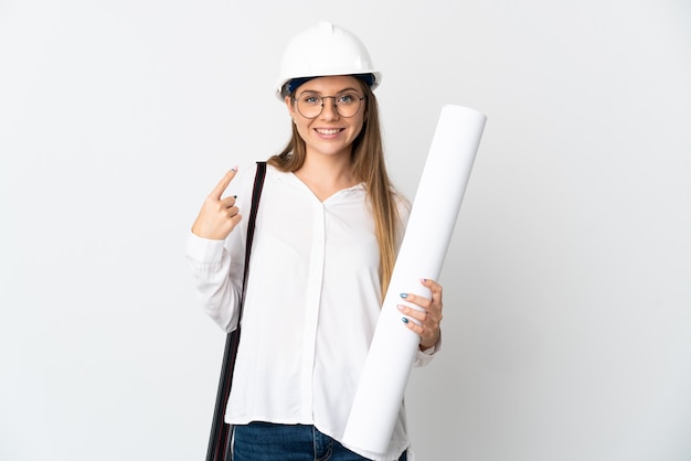 Junge litauische Architektin Frau mit Helm und hält Blaupausen lokalisiert auf weißer Wand, die eine Daumen hoch Geste geben