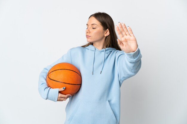 Junge litauische Frau, die Basketball spielt, lokalisiert auf weißem Hintergrund, der Stoppgeste macht und enttäuscht