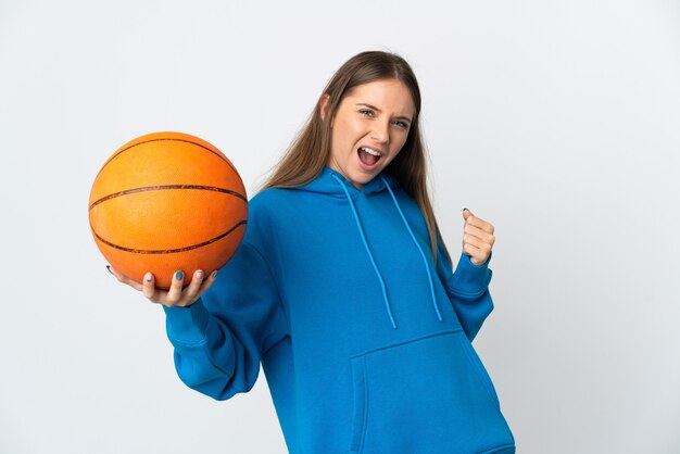 Junge litauische Frau lokalisiert auf weißer Wand, die Basketball spielt