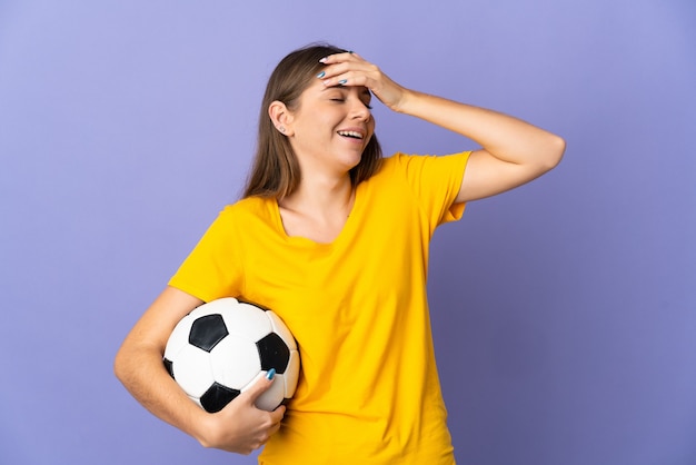 Junge litauische Fußballspielerfrau lokalisiert auf lila Hintergrund, der viel lächelt