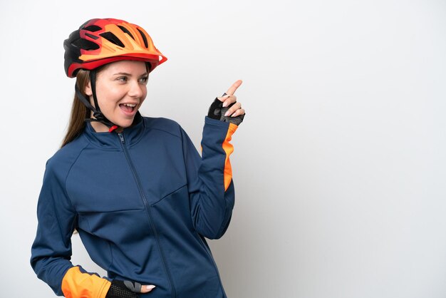 Junge litauische Radfahrerin isoliert auf weißem Hintergrund, die mit dem Finger zur Seite zeigt und ein Produkt präsentiert