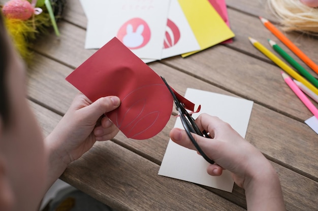 Junge macht Ostergrußkarte Materialien für künstlerische Kreativität auf dem Kindertisch Kinder malen