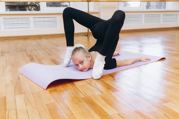 Junge Mädchen, die Gymnastikübungen machen oder im Fitnessunterricht trainieren