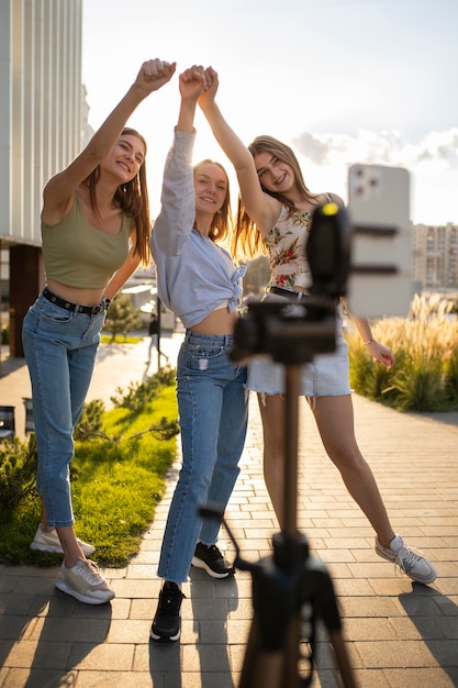Junge Mädchen im Teenageralter nehmen Rollen von sich selbst im Freien für soziale Medien auf