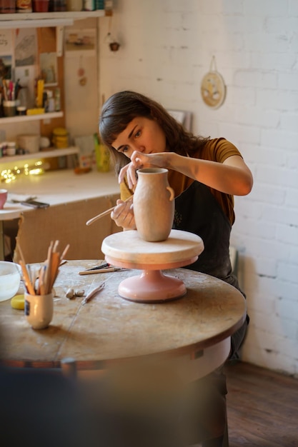 Junge Mädchen, Kunstkursstudentin oder Besitzerin eines Keramikstudios, erstellen eine Vase für die Meisterklasse in der Werkstatt