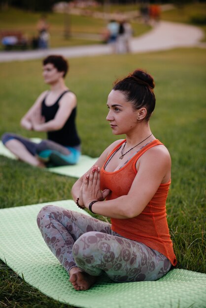 Junge Mädchen machen Yoga im Freien im Park während des Sonnenuntergangs. Gesunder Lebensstil.