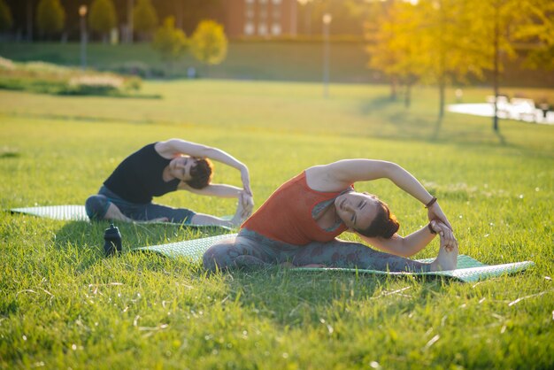 Junge Mädchen machen Yoga im Freien im Park während des Sonnenuntergangs. Gesunder Lebensstil.