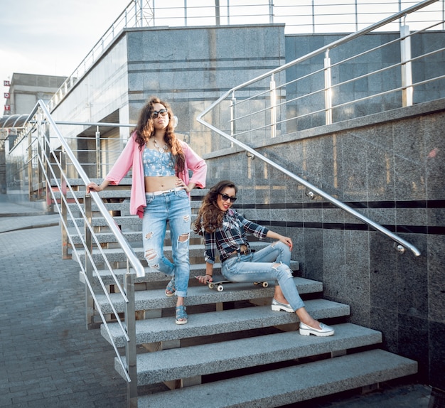 Junge Mädchen mit Skateboard sitzen auf der Treppe