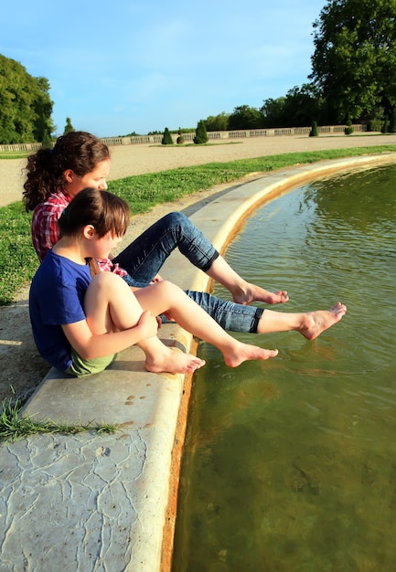 Junge Mädchen spielen mit dem Brunnen