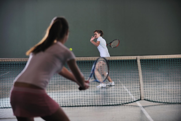 Foto junge mädchen spielen tennis im innenraum