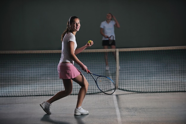 junge Mädchen spielen Tennis im Innenraum