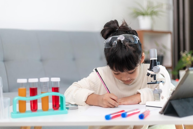 Junge Mädchen spielen wissenschaftliche Experimente für den Heimunterricht