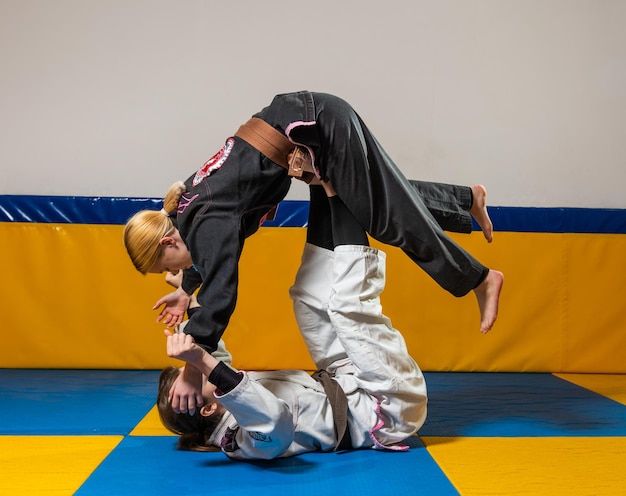 Junge Mädchen üben im Fitnessstudio brasilianisches Jiu-Jitsu