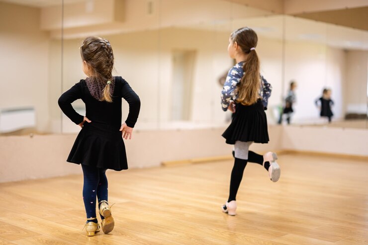 Junge Mädchen üben Tanzbewegungen in einem Tanzstudio mit Spiegeln