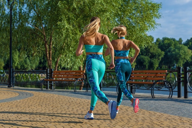 Junge Mädchensportlerin engagiert sich morgens auf einem Sportplatz Fitnessübungen mit Schleifen