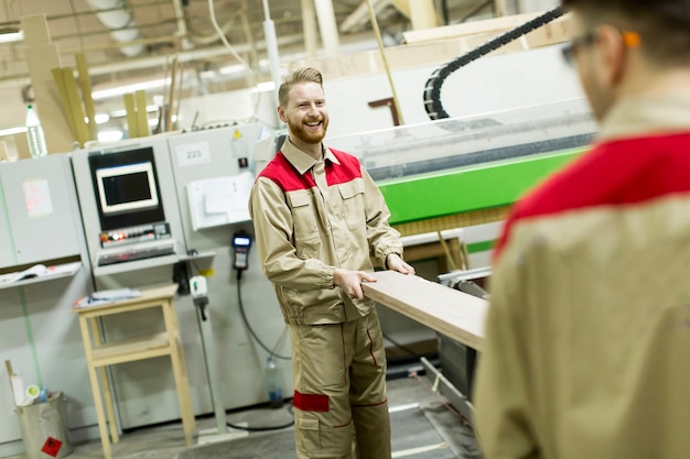 Foto junge männer, die in der möbelfabrik arbeiten