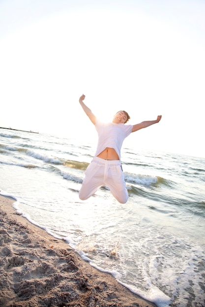 Junge männer springen am strand im morgengrauen