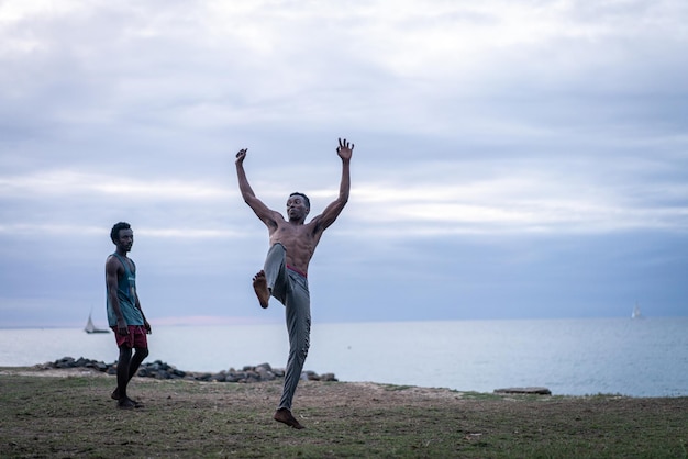 Junge Männer trainieren Kampfsport am Strand