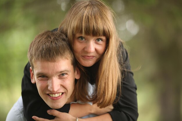 Junge Männer und Mädchen in der Natur umarmen und küssen