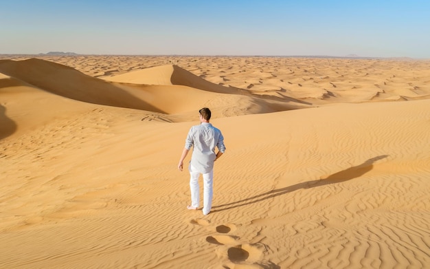 Junge Männer wandern in der Wüste von Dubai. Sanddünen in der Sandwüste von Dubai, Vereinigte Arabische Emirate