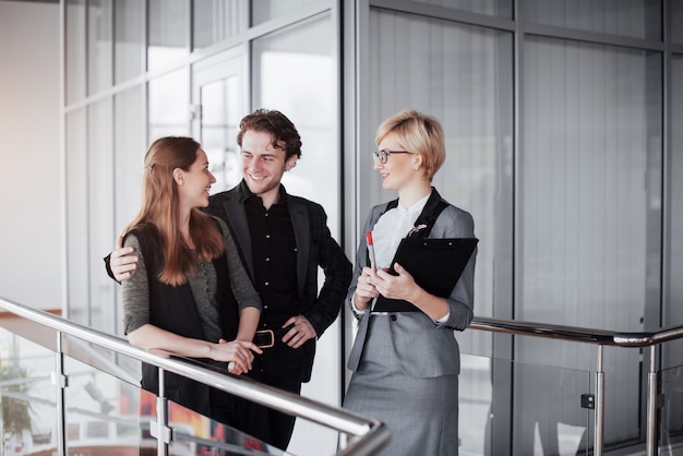 Junge männliche und weibliche Mitarbeiter, die produktiven Arbeitsprozess im Büro, lächelnde Studenten besprechen und planen