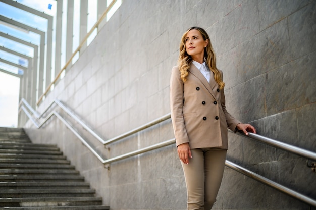 Junge Managerin, die auf die Treppe geht