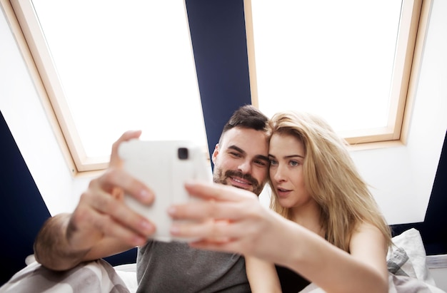 Junge Mann benutzt zu Hause ein Mobiltelefon
