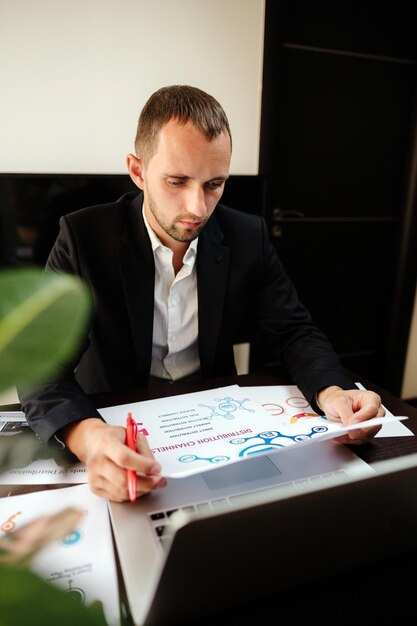 Foto junge mann macht ein gesicht, während er auf dem tisch sitzt