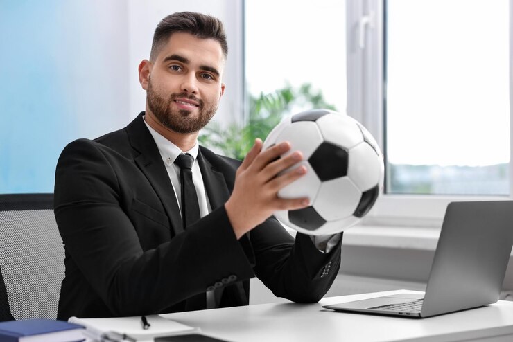 Foto junge mann mit fußball am tisch im büro