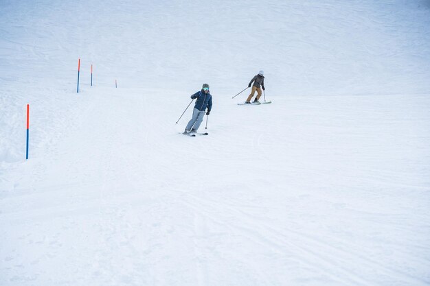 Junge Menschen fahren an einem Wintertag im schneebedeckten Hochgebirge Ski. Konzentrieren Sie sich auf das Gesicht des Vordermanns