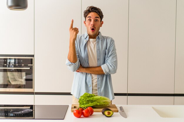 Junge Mischlinge, die einen Salat zum Mittagessen zubereiten und eine großartige Idee haben, Konzept der Kreativität.